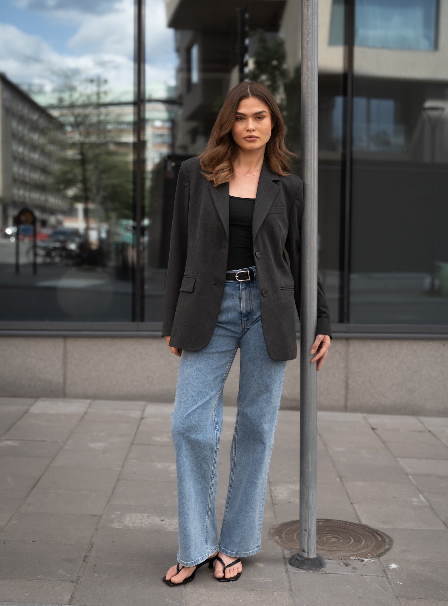 Woman wearing Ninepine Relaxed Light ComfortDenim™ jeans styled with The Perfect Blazer and a black Strappy Tank for a minimalist everyday outfit.